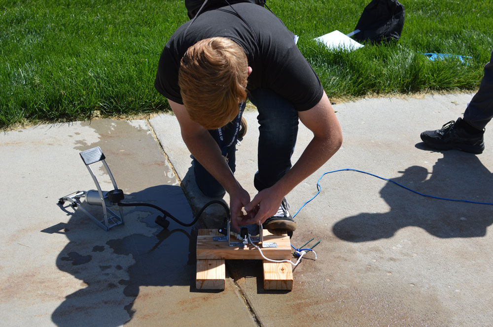 Student setting up the launch pad for a bottle rocket