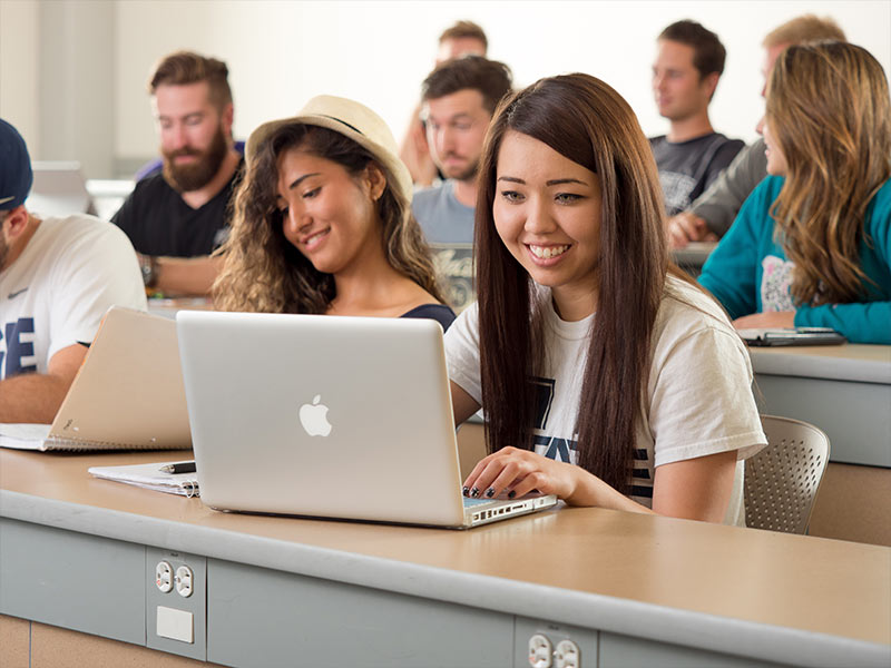 Engineering student sitting in on Dr. Lawanto's class smilling