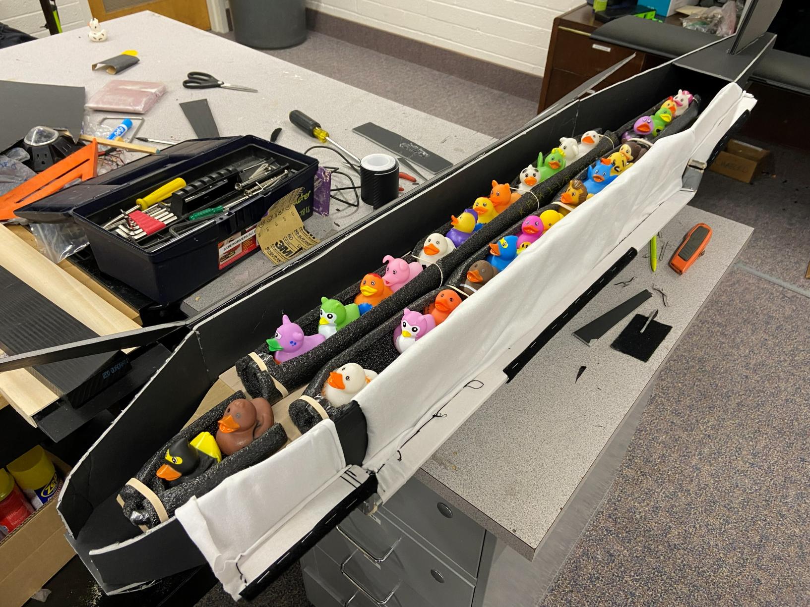 The passenger duck restraint system laid down in the fuselage with white cloth serving as the top restraint covering the rubber ducks.